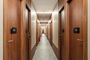 a hallway with wooden doors and a long aisle at Fast Sleep Guarulhos by Slaviero Hotéis in Guarulhos +30 photos