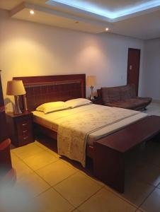 ein Schlafzimmer mit einem großen Bett und einer Couch in der Unterkunft Serrano Park Hotel in Parauapebas