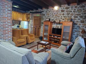 a living room with two couches and a tv at Casa Nardo in Benia de Onís