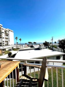 a deck with a chair and a view of the beach at Wake up 2 Quiet Ocean Views, centrally located A1A in Ormond Beach