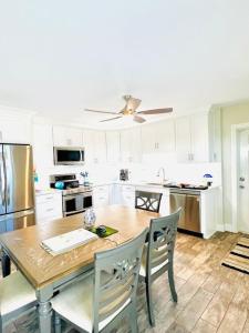 a kitchen with a wooden table with chairs and a ceiling fan at Wake up 2 Quiet Ocean Views, centrally located A1A in Ormond Beach