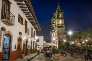 a building with a clock tower in a town at night at Hotel Campestre, Valle de Bravo in Valle de Bravo