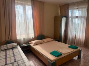a bedroom with a twin bed and two windows at Vila George in Eforie Sud