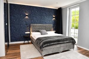 a bedroom with a bed and a blue wall at Hotel Kornblume in Haundorf