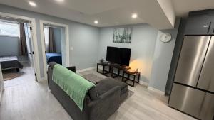 a living room with a couch and a television at Entire 2BR Suite 12 min to Airport in Calgary