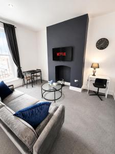 a living room with a couch and a fire place at The Quayside Apartments - Central, Steps to Gloucester Quays, Parking and Smart TV in Gloucester
