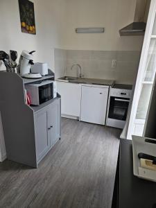 a kitchen with white cabinets and a sink at Studio in Bonny-sur-Loire