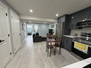 a kitchen and living room with a table and chairs at Entire 2BR Suite 12 min to Airport in Calgary