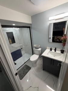 a bathroom with a shower and a toilet and a sink at Entire 2BR Suite 12 min to Airport in Calgary +4 photos
