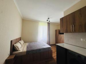a small bedroom with a bed and a window at Due apartments in Borjomi