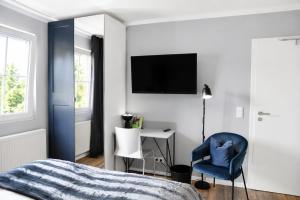 a bedroom with a bed and a chair and a desk at Hotel Kornblume in Haundorf