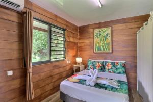 a bedroom with a bed with a stuffed bunny on it at Fare Heimery - Private Lagoon Beach in Haapiti