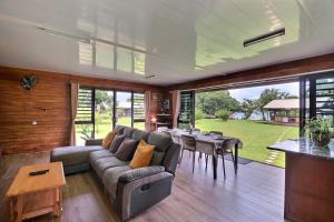 a living room with a couch and a table at Fare Heimery - Private Lagoon Beach in Haapiti