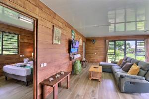 a living room with a couch and a table at Fare Heimery - Private Lagoon Beach in Haapiti +27 photos