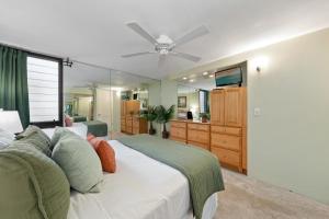 a bedroom with a white bed with a ceiling fan at Kaleialoha 211 · KA 211 OceanFront 1BD Whale Watch Relax Getaway in Kahana +49 photos