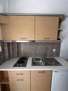 a kitchen with a sink and a stove and cabinets at Barbara House in Kriopigi