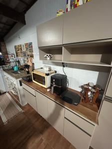 a kitchen with a counter top with a microwave at Hospedagem Dorna Itaguaí Casa 6B in Itaguaí