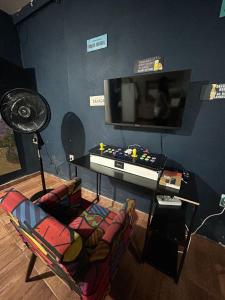 a living room with a tv and a chair and a table at Hospedagem Dorna Itaguaí Casa 6B in Itaguaí