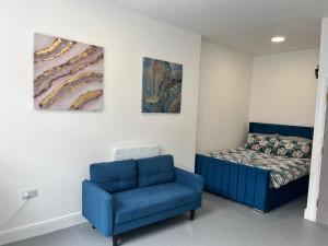 a bedroom with a blue couch and a bed at Cosy flat in central Cardiff Bay in Cardiff