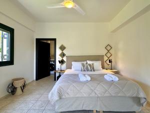 a bedroom with a bed with two towels on it at Villa Nynemia Almyrida Crete in Plaka +56 photos