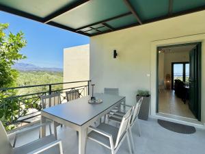 a table and chairs on the balcony of a house at Villa Nynemia Almyrida Crete in Plaka