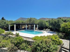 a swimming pool with a gazebo in a garden at Villa Nynemia Almyrida Crete in Plaka