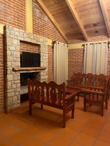 a room with benches and a fireplace with a tv at Zidada Mundo Magico in Huasca de Ocampo