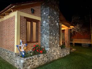 a brick house with a window and some flowers at Zidada Mundo Magico in Huasca de Ocampo