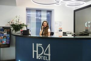 a woman talking on a cell phone at a reception desk at Hotel 54 Barceloneta in Barcelona