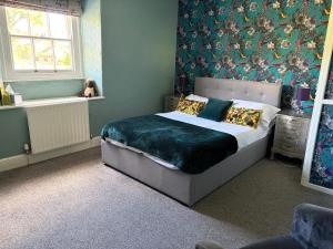 a bedroom with a bed with a green comforter at Bolton arms downholme in Richmond