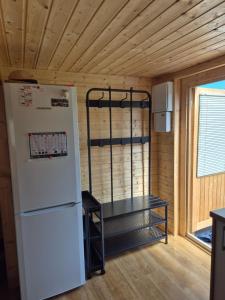 a refrigerator and a shelf in a tiny house at Domek pod Wierzbami in Leleszki +11 photos