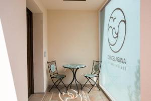 a table and two chairs in a room with a window at Guest House Dolce Laguna in Tessera