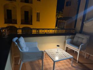 two chairs and a table on a balcony at Riviera Blu Rooms in Laigueglia