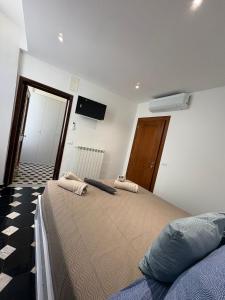 a bedroom with a large bed and a tv on the wall at Riviera Blu Rooms in Laigueglia +7 photos