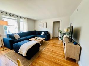 a living room with a blue couch and a tv at Inn on Willard in South Portland