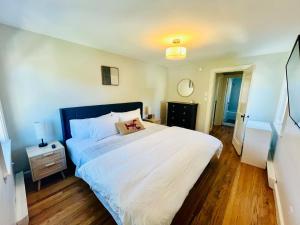 a bedroom with a large white bed with a wooden floor at Inn on Willard in South Portland