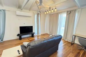 a living room with a couch and a flat screen tv at Pool house in Marsden