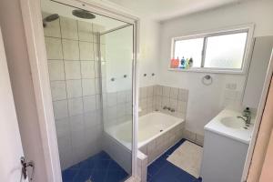 a bathroom with a shower and a tub and a sink at Pool house in Marsden +10 photos