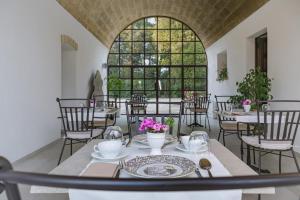 a dining room with tables and chairs and a large window at Villa Tuzzo in Lecce