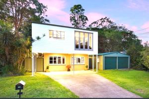 a yellow and white house with a driveway at Pool House with 3 BDR 2 AC in Marsden