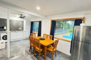 a kitchen with a table and chairs and a refrigerator at Pool House with 3 BDR 2 AC in Marsden