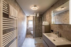 a bathroom with a sink and a toilet at DORFSTUDIO Apartments in Söll