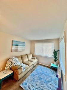 a living room with a couch and a blue rug at Steps to Private Beach Access King Beds in Ormond Beach