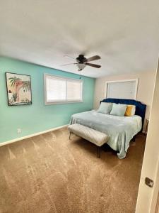 a bedroom with a bed and a ceiling fan at Steps to Private Beach Access King Beds in Ormond Beach