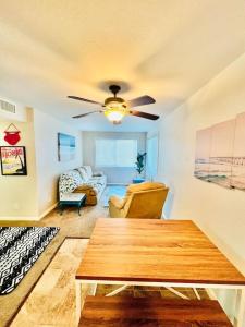 a living room with a ceiling fan and a table at Steps to Private Beach Access King Beds in Ormond Beach