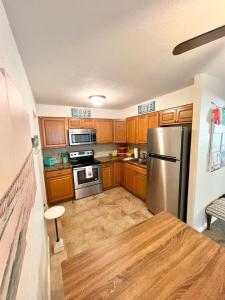 a kitchen with wooden cabinets and a stainless steel refrigerator at Steps to Private Beach Access King Beds in Ormond Beach +19 photos