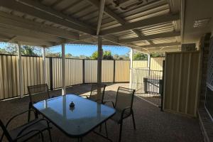 a glass table and chairs on a patio at SPA House 4 BDR 5 beds Master with AC) in Boronia Heights