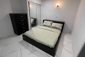 a bedroom with a bed and a dresser and a mirror at SPA House 4 BDR 5 beds Master with AC) in Boronia Heights