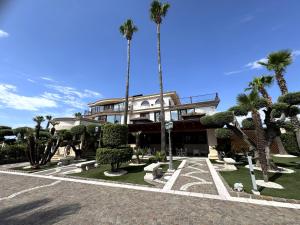 a building with palm trees in front of it at Le Tre Rose di Metta in Cerignola