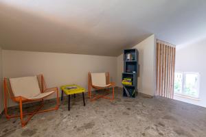a room with two chairs and a table and a shelf at DORFSTUDIO Apartments in Söll